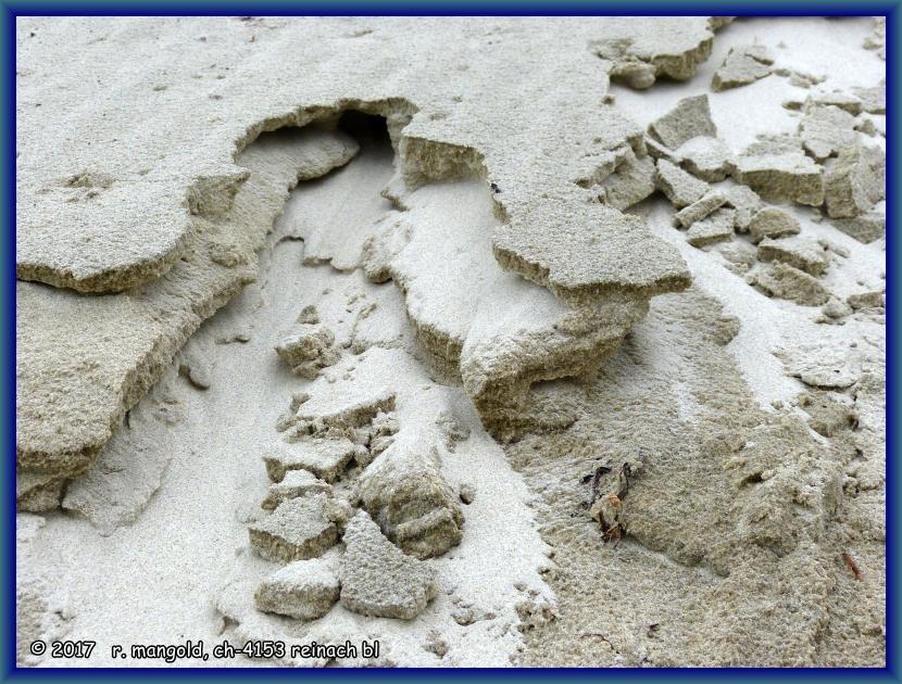 der sandige strand rutscht portionenweise immer weiter ins meer