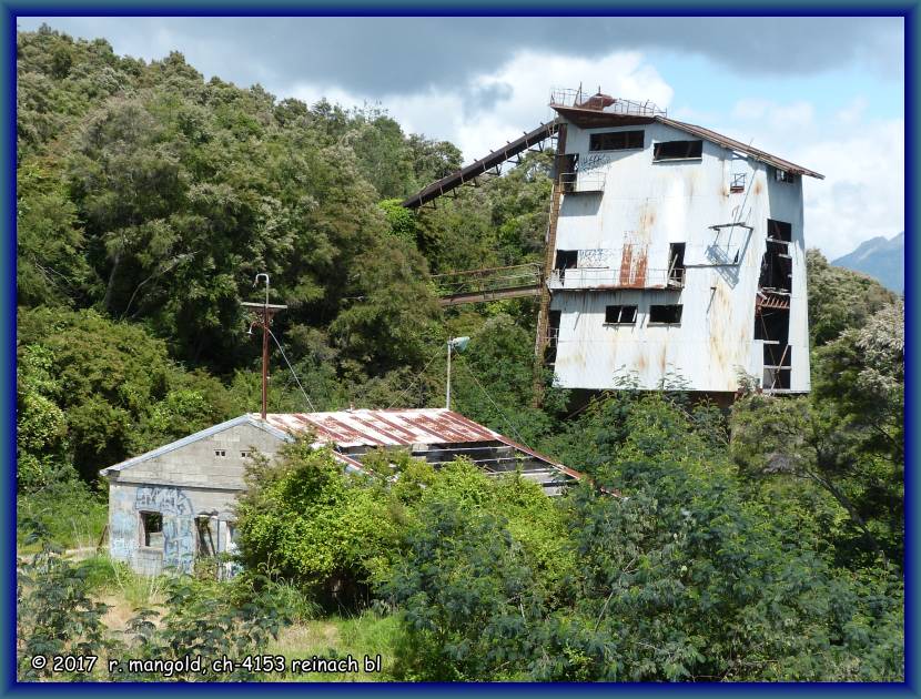 ein nicht mehr genutztes, verfallenes gebude direkt neben der strasse am fluss