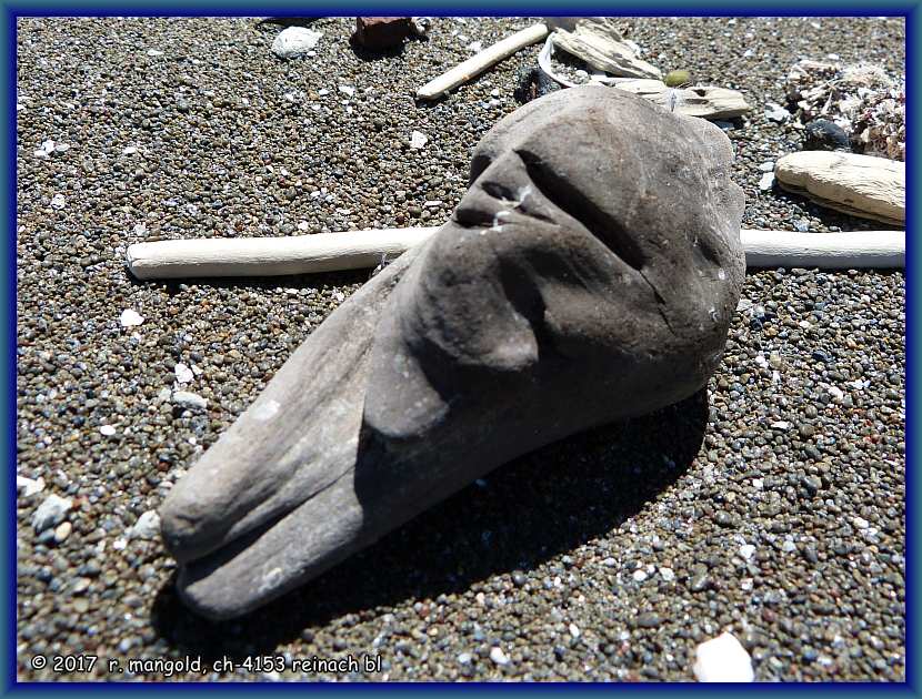 kopf und rumpfteil der meeresgttin im sand auf dem weg nach mahia beach