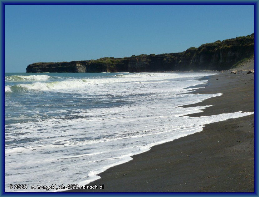der schwarze sandstrand mit der steilküste an der patea beach (neuseeland nordinsel) am 04.02.2018