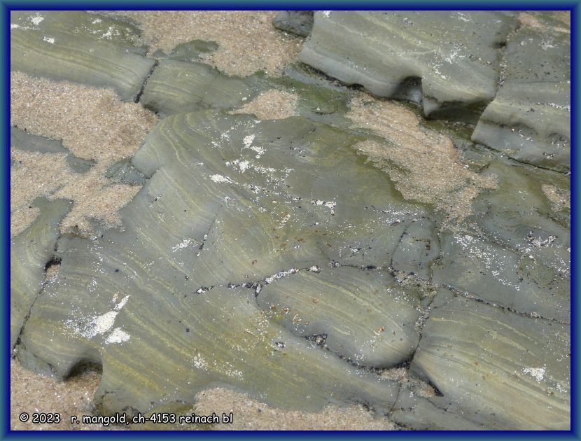sch&ouml;n gestreift und erodiert, fels im sand der martinsbucht bei omapere (neuseeland nordinsel) am 25.11.2017